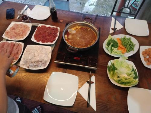 a table with plates of food and a pot of soup at Palms Villa in Negombo