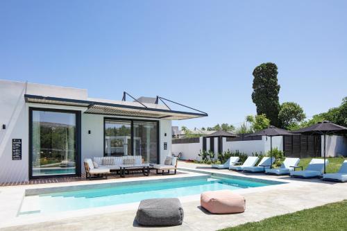 a villa with a swimming pool and a patio at Physis Villas - Metal & Wood in Pigi