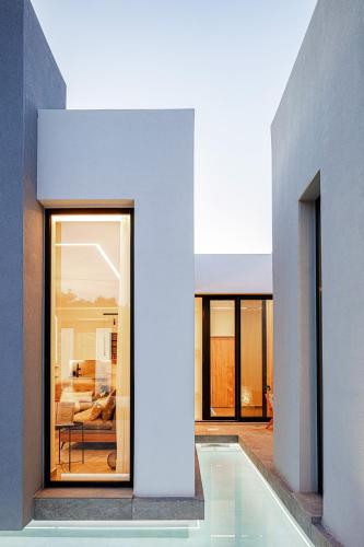 a house with a swimming pool next to a bedroom at Physis Villas - Metal & Wood in Pigi