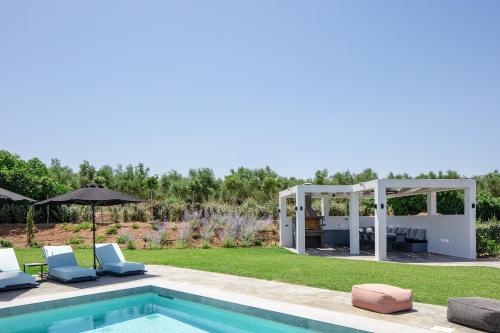 a backyard with a pool and a gazebo at Physis Villas - Metal & Wood in Pigi