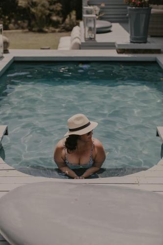 a woman in a hat in a swimming pool at Qambathi Mountain Lodge in Kamberg Valley