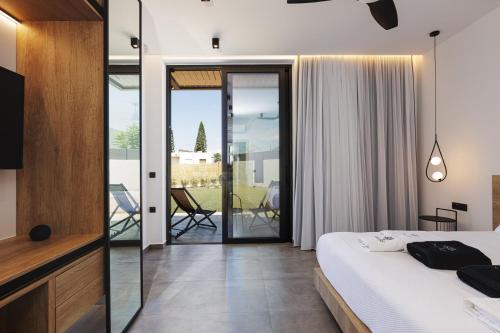 a bedroom with a bed and a sliding glass door at Physis Villas - Metal & Wood in Pigi