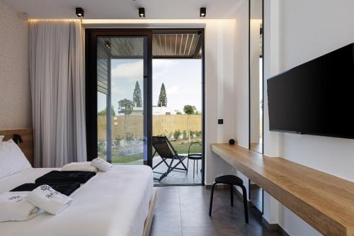 a hotel room with two beds and a flat screen tv at Physis Villas - Metal & Wood in Pigi