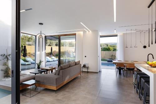 a kitchen and living room with a couch and a table at Physis Villas - Metal & Wood in Pigi
