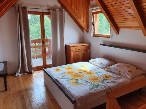 Un dormitorio con una cama con flores amarillas. en Pan Koran Vikendica Pale, Jahorina en Pale