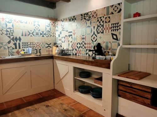 a kitchen with white cabinets and a sink and tiles at Granja Labrada: Alojamiento con caballos in Santa María