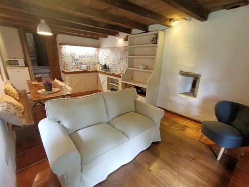 a living room with a white couch and a kitchen at Granja Labrada: Alojamiento con caballos in Santa María