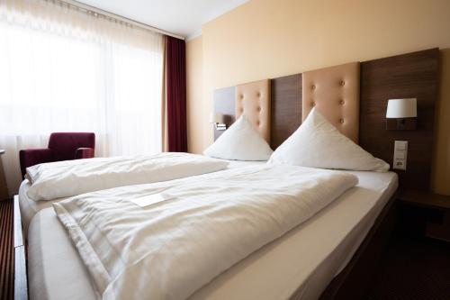Ein Bett oder Betten in einem Zimmer der Unterkunft Europa Kehl Hotel