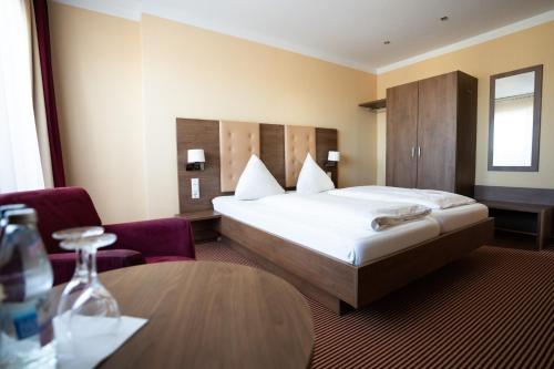 ケール・アム・ラインにあるエウロパ ケール ホテルのベッドとテーブルが備わるホテルルームです。