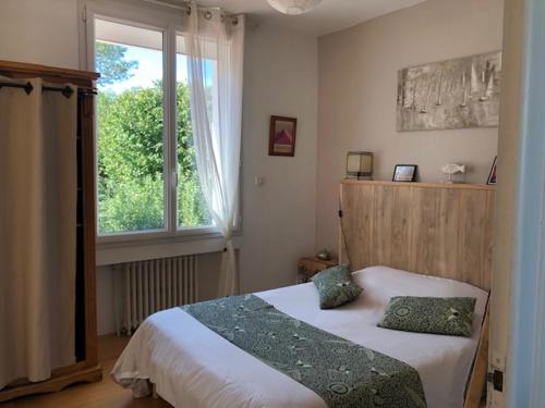 1 dormitorio con 1 cama con 2 almohadas y ventana en Nuits océanes à La Rochelle avec parking privatif, en La Rochelle