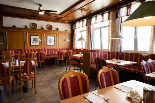 un restaurante con mesas, sillas y ventanas en Europa Kehl Hotel, en Kehl am Rhein
