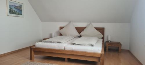 un letto con cuscini bianchi sopra di Ferienwohnung Seeblick a Northeim