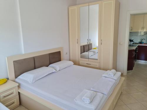 1 dormitorio con 1 cama blanca grande y toallas. en Seascape Apartments Vlore, en Vlorë