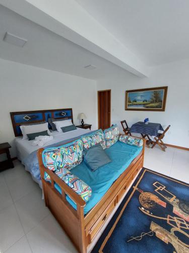 a bedroom with a large bed and a couch at Lumiar Eco Lodge - Chalé Telhado Verde in Nova Friburgo