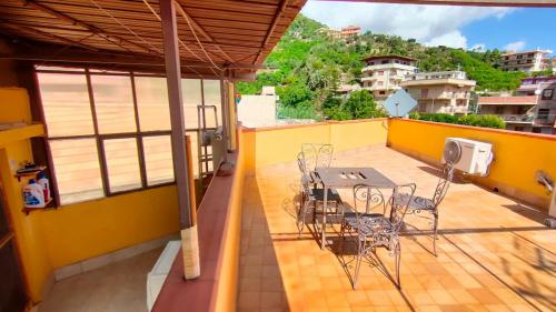 a patio with a table and chairs on a balcony at CASA SOPRANO da Anita in Messina