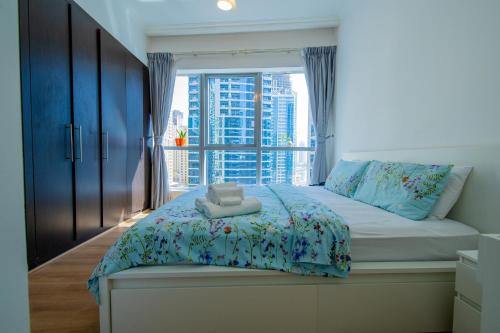 una camera da letto con un letto e una grande finestra di Full Apartment in Dubai Marina,80m from beach a Dubai