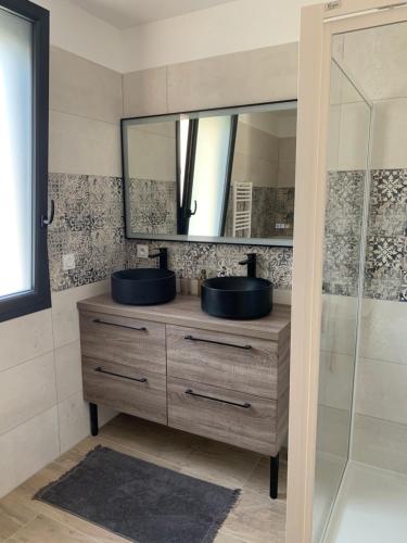 a bathroom with a sink and a mirror at La maison de la vallée in Ranville