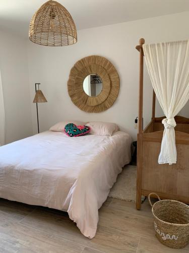 une chambre avec un lit et un miroir au mur dans l'établissement La maison de la vallée, à Ranville