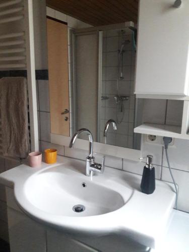 a bathroom sink with two faucets and a mirror at Ferienwohnung auf der sonnigen Südseite in Langenegg