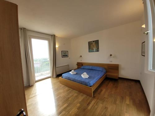 a bedroom with a blue bed and a large window at Villa delle Gazanie -Camera in villa -Vista panoramica sul Golfo in Quartu SantʼElena