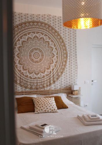 a bedroom with a large bed with a large headboard at TENUTA BILUCCIO B & B in Roccadaspide