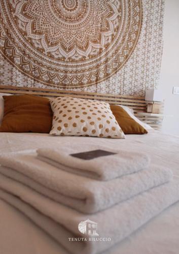 a bedroom with a bed with a large headboard at TENUTA BILUCCIO B & B in Roccadaspide