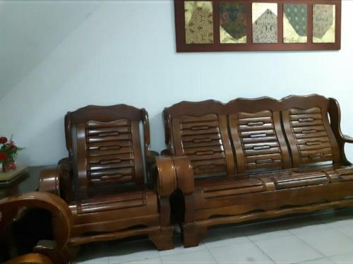 two wooden couches sitting next to each other at MELAKA HOTEL SENTOSA in Melaka