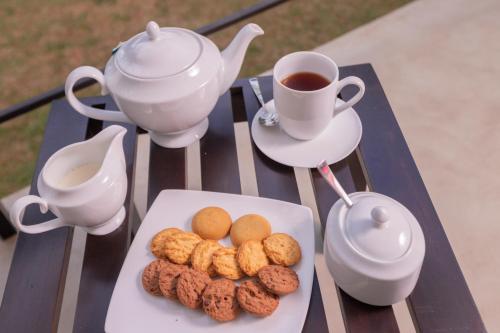 a table with a plate of cookies and a cup of tea at Serendipity Lake - Hikkaduwa in Hikkaduwa