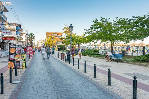 a city street with people walking down a sidewalk at Lucia Hotel Paralia in Paralia Katerinis