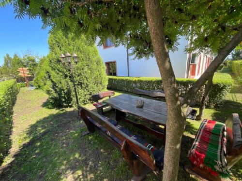 a picnic table under a tree next to a house at PANTELI APART HOUSE in Aheloy