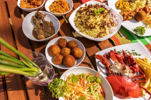 a table with many plates of food on it at Serendipity Lake - Hikkaduwa in Hikkaduwa