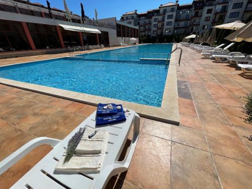 a swimming pool with a table and chairs next to a building at PANTELI APART HOUSE in Aheloy