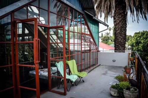 a couple of green chairs sitting on a porch at (Sub)urban retreat in Johannesburg