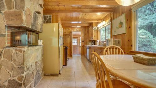 a kitchen and dining room with a stone wall at Crystal Creek Chalet - Meredith Lodging in Welches