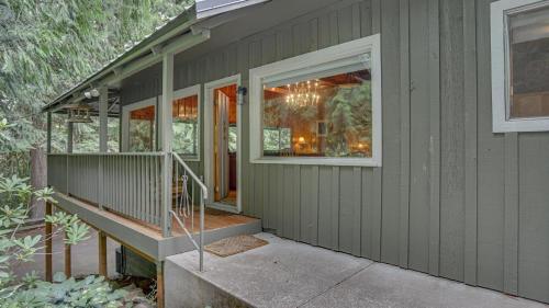 a green house with a staircase and a window at Crystal Creek Chalet - Meredith Lodging in Welches
