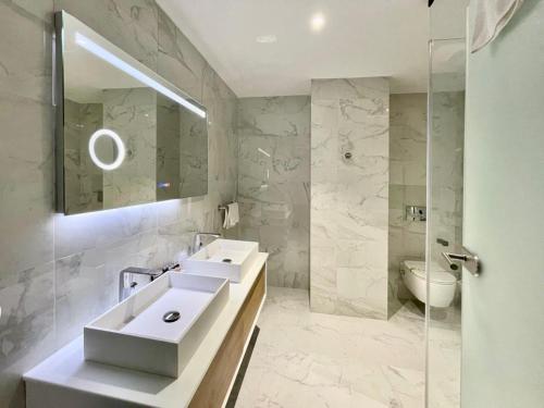 a bathroom with two sinks and a mirror and a toilet at Aniroc Signature Hotel in Arad