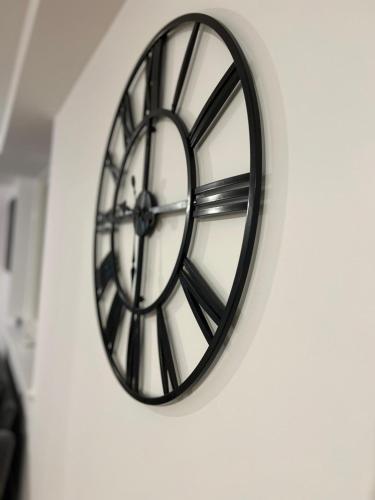 a black and white clock on a wall at 2 Bed Penthouse-Riverside View in East London in Barking