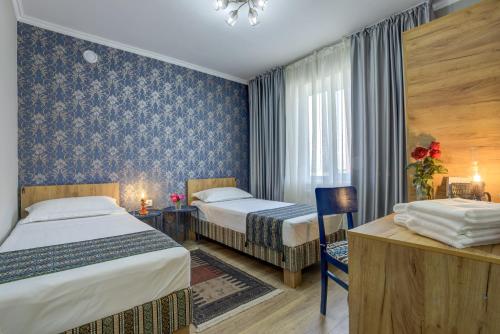 a hotel room with two beds and a desk at Ordo Hotel in Karakol