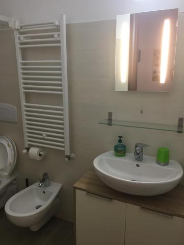 bagno con lavandino, specchio e servizi igienici di La Casa del Giglio a Matera