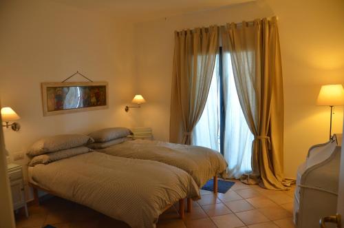 a bedroom with two beds in front of a window at Villa Ca' Bianca in Finale Ligure