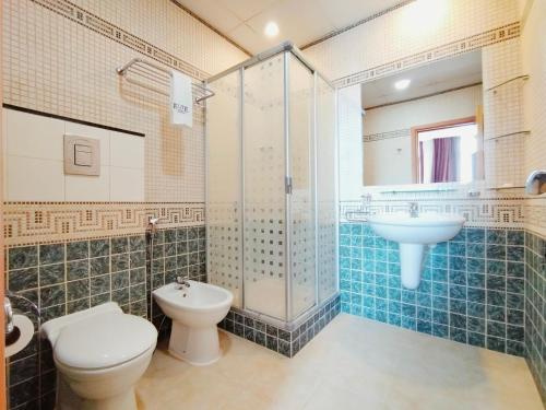 a bathroom with a toilet and a sink and a shower at Elite Tower in Seef