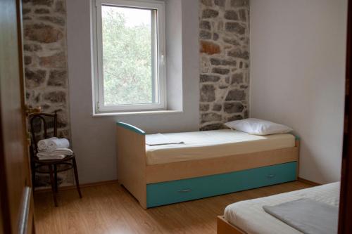 a small bedroom with a bed and a window at House Antica in Lastovo