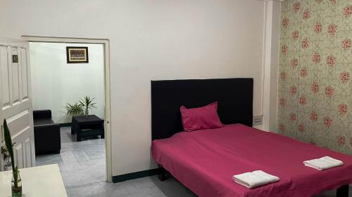1 dormitorio con 1 cama con manta rosa en Abu Homestay, en Kohīma