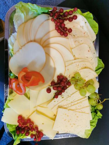 a plate of food with cheese and fruits and vegetables at Akteon Hotel in Stuttgart