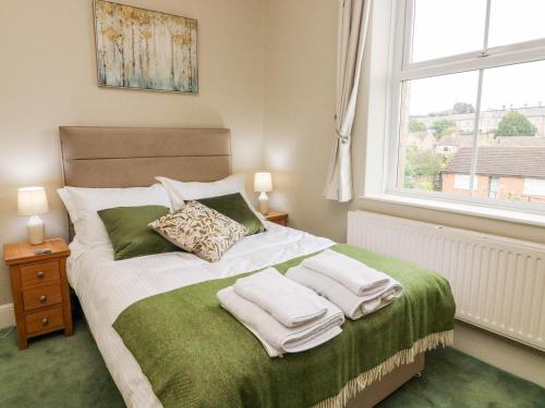 um quarto com uma cama com toalhas em Heanor House em Leyburn