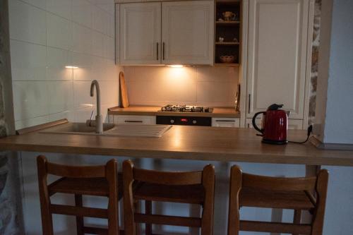a kitchen with a counter with chairs and a sink at House Antica in Lastovo