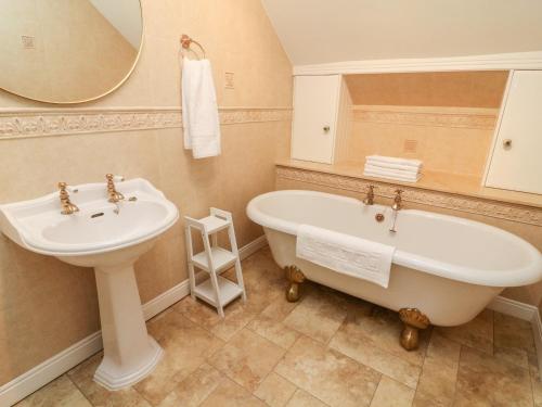 萊本的住宿－Heanor House，一间带水槽、浴缸和镜子的浴室
