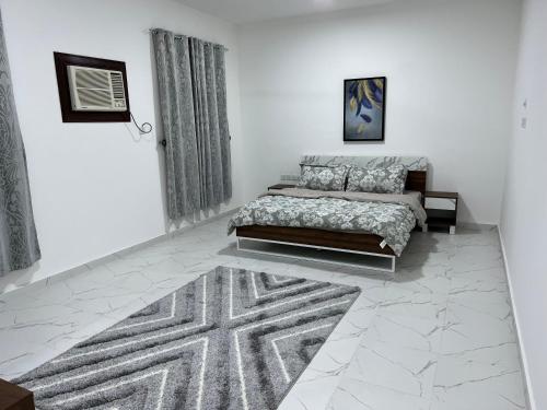 a bedroom with a bed and a rug at Al Shiya Chalet in Sur