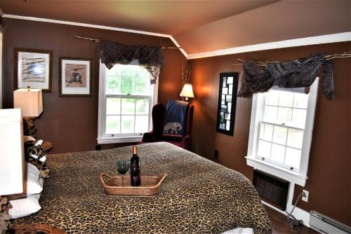 a bedroom with a bed and two windows at Admiral Peary Inn in Fryeburg