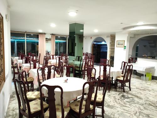 un comedor con mesas y sillas en un restaurante en Hotel Sorriso, en San Remo